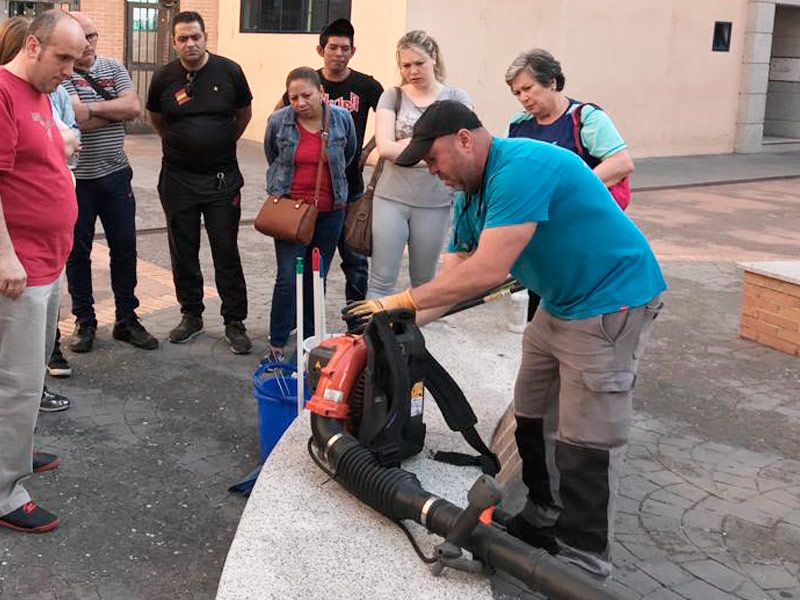 Profesional de Luzsola haciendo una demostración con materiales de limpieza a los alumnos en una formación práctica