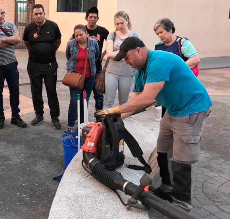 Profesional de Luzsola haciendo una demostración con materiales de limpieza a los alumnos en una formación práctica